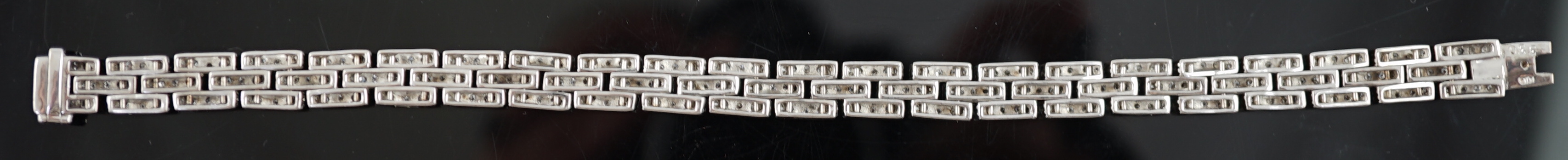 An 18k white gold and diamond chip set triple row bracelet